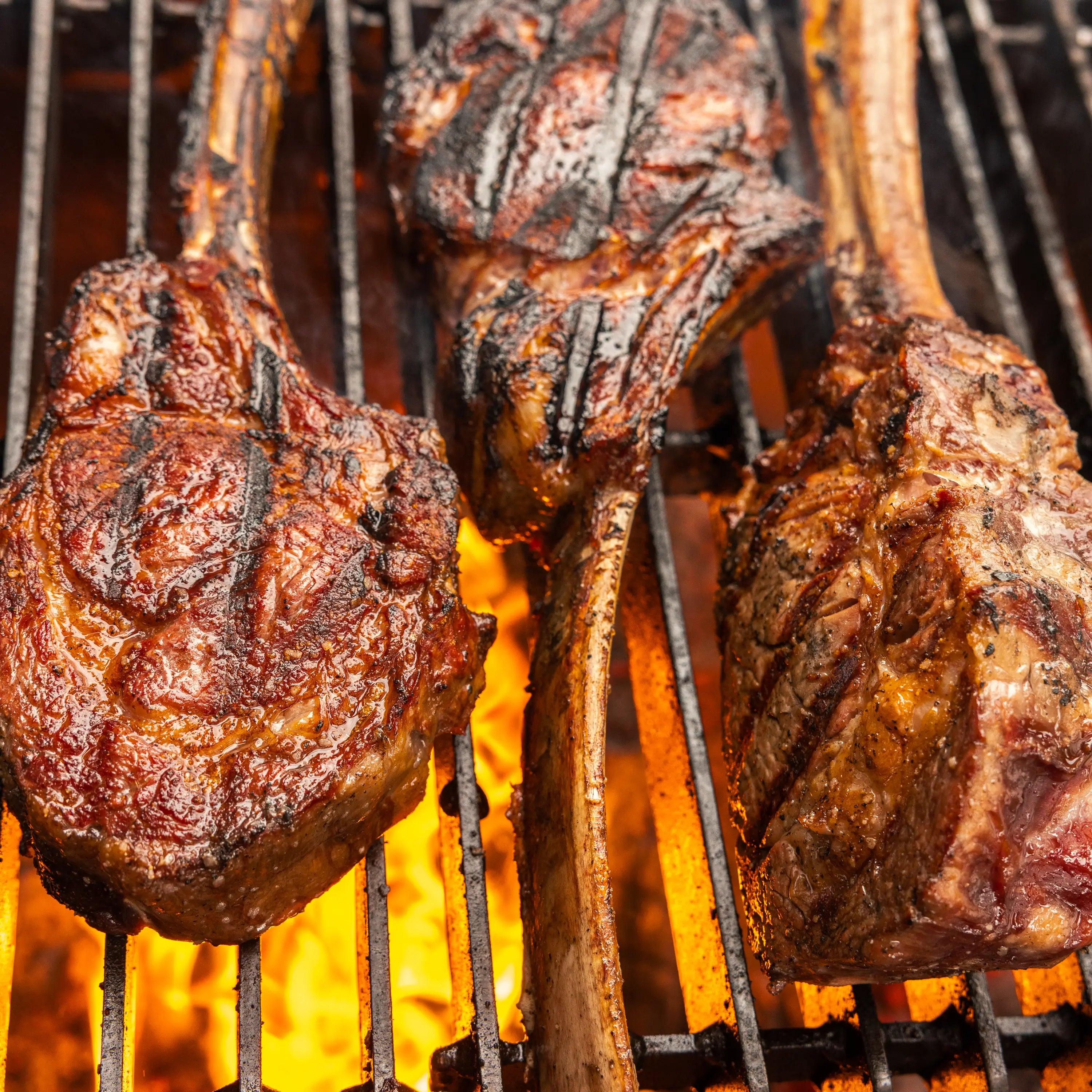 Cooked meat on grill with flames under