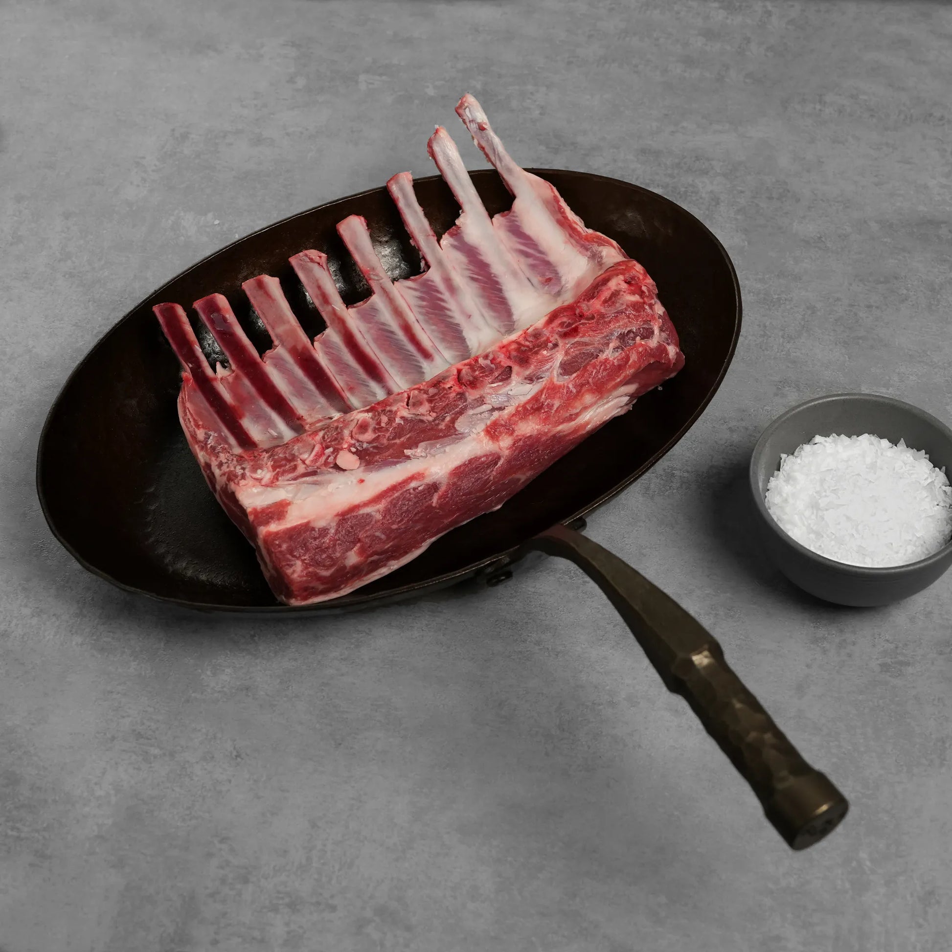 Allen Brothers Domestic all natural rack of lamb raw on a black pan 