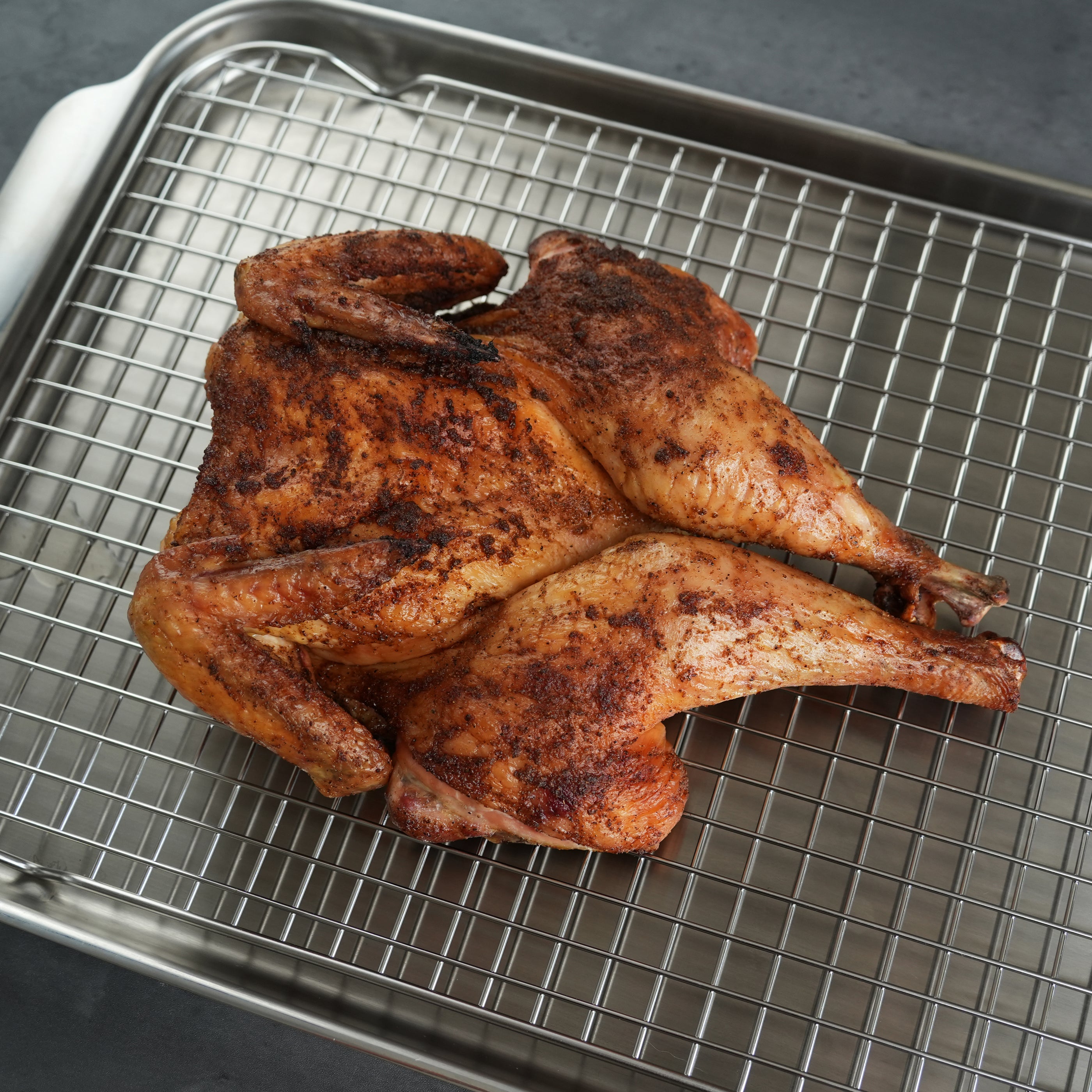 LaBelle Patrimoine Spatchcock Whole Chicken cooked on  silver sheet pan on grey slate background