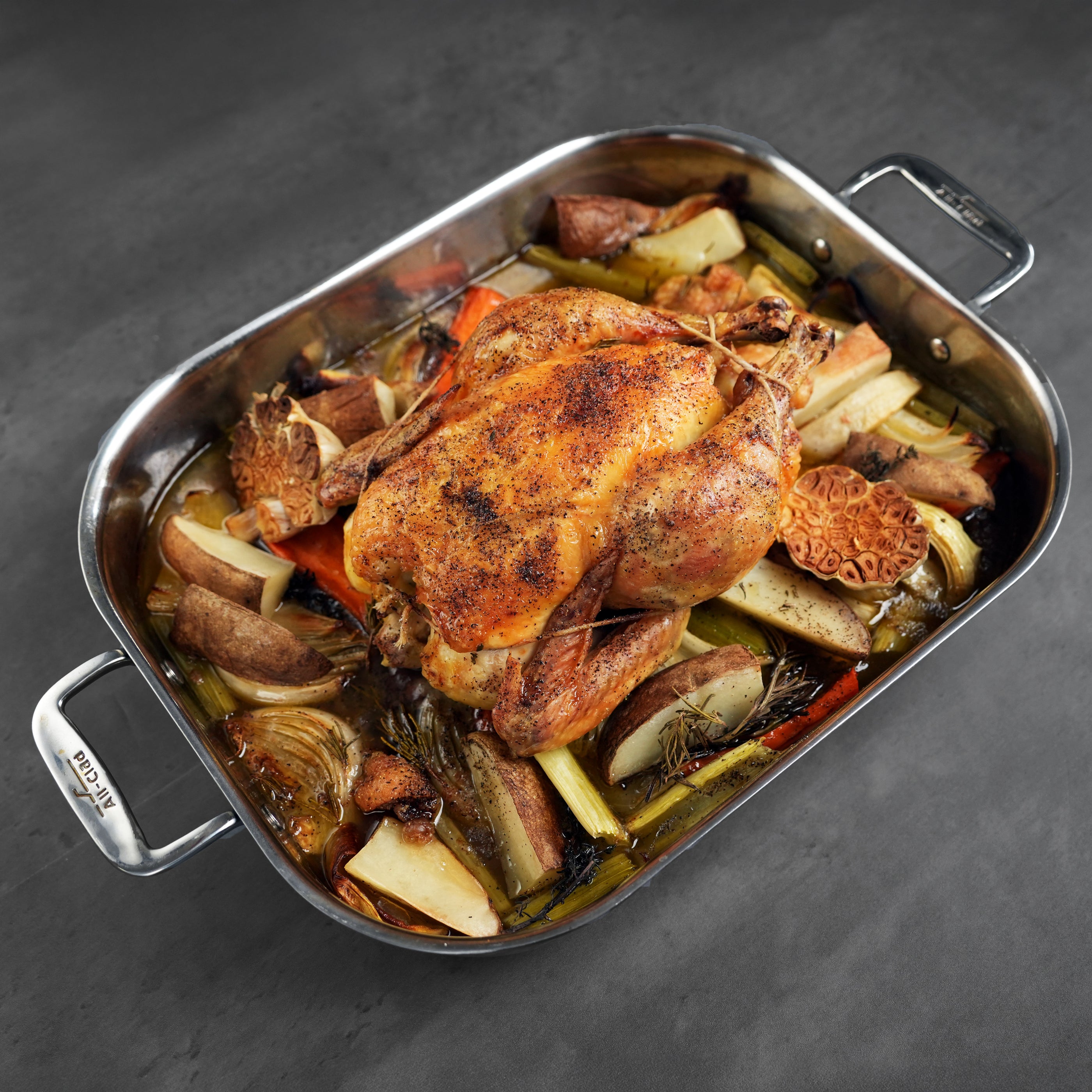 LaBelle Patrimoine Whole Chicken cooked and tied in a prep tray on a grey slate background