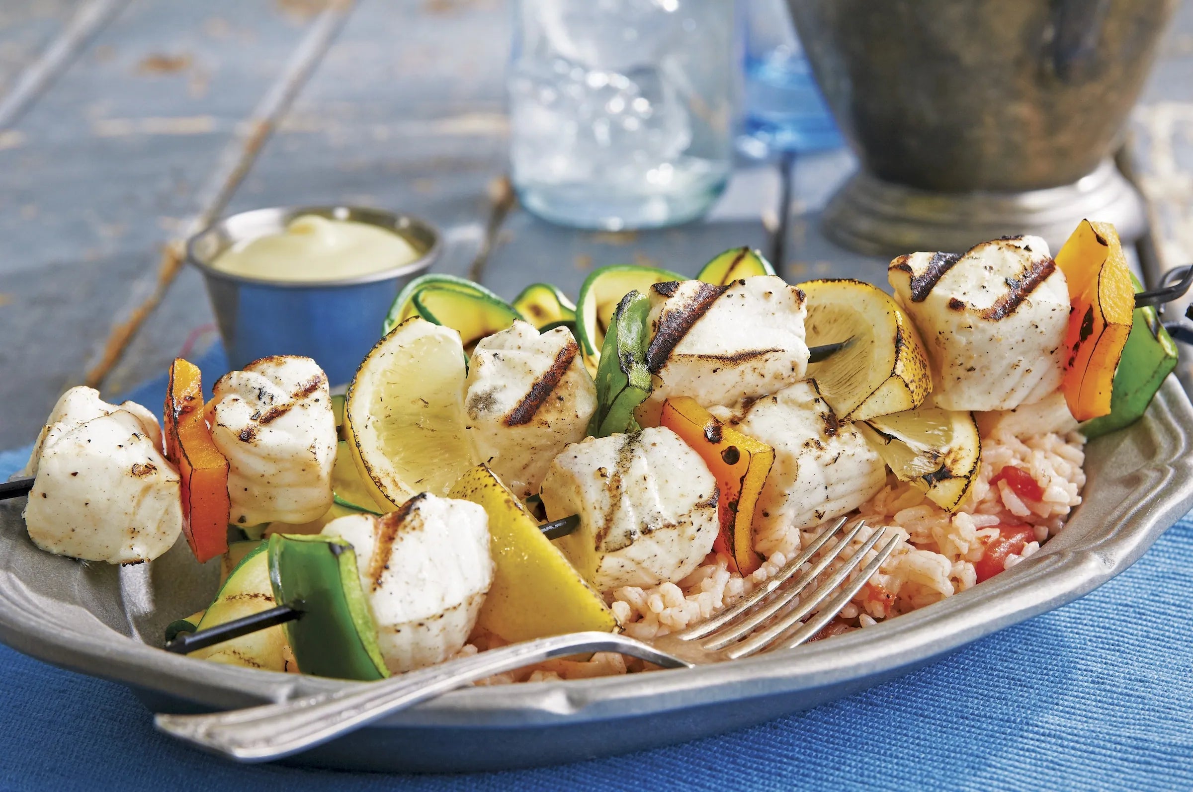 Grilled white fish on skewers with vegetables and rice